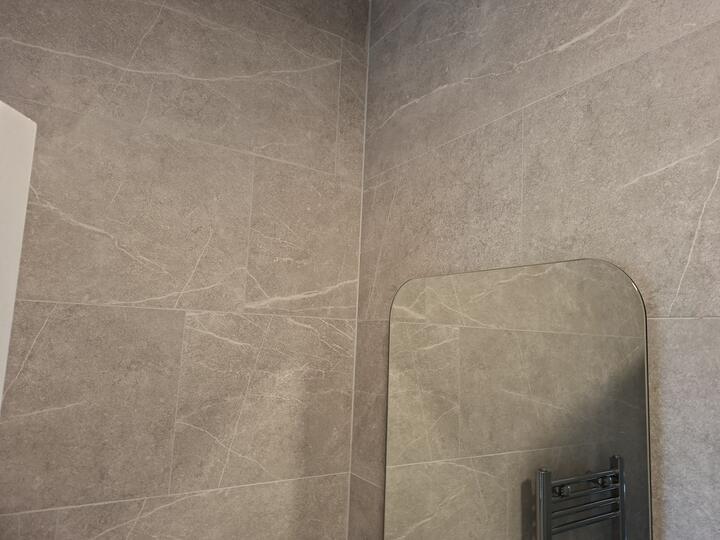 Tiled bathroom wall with an internal corner and mirror