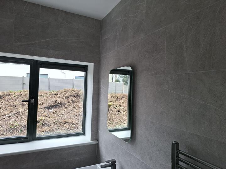 Window reveal tiled with neat edges and a mirror on the tiled wall